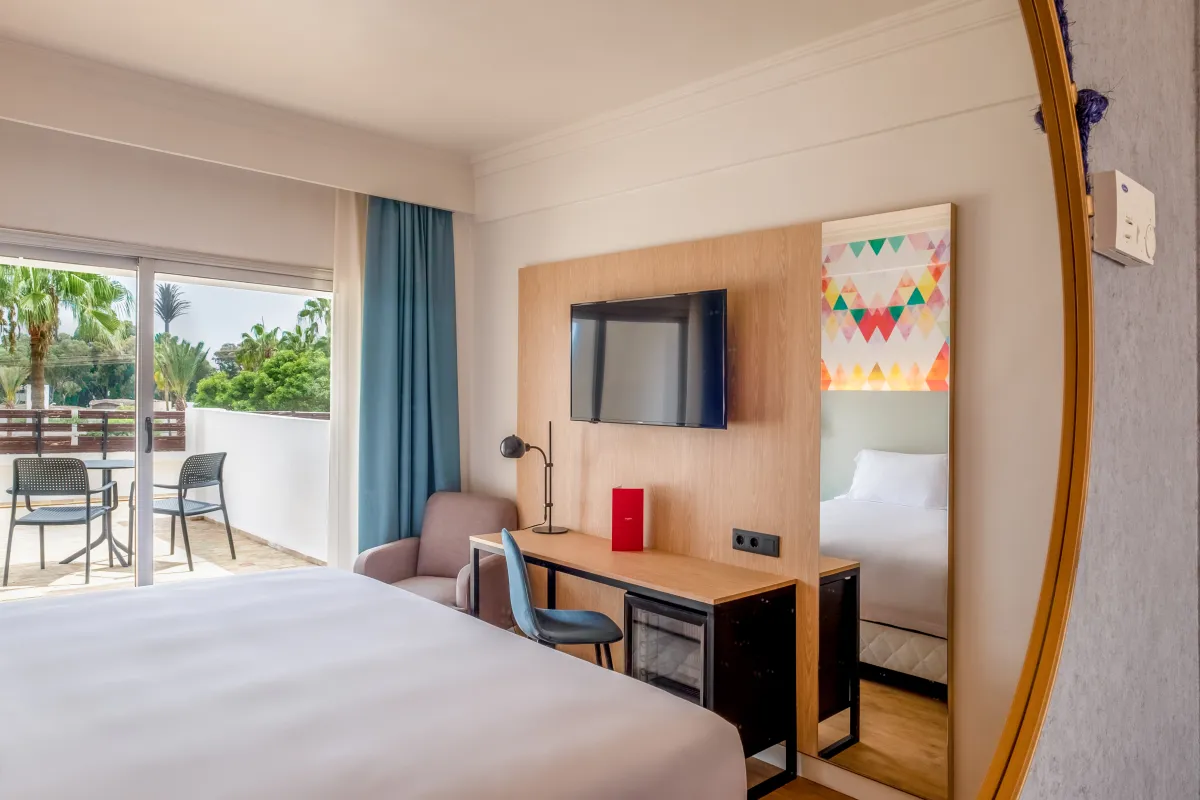 Escritorio y espejo de una habitación del Barceló Allegro Agadir, con la terraza al fondo