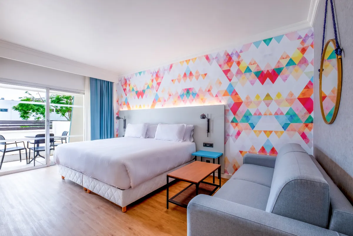 Habitación del Barceló Allegro Agadir con la pared del cabecero impresa en triángulos de colores