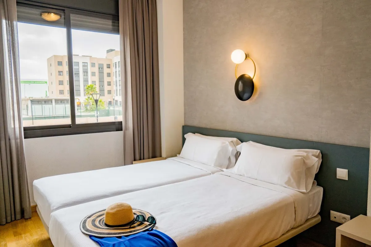 Dormitorio del Compostela Suites con dos camas y un cabecero corrido