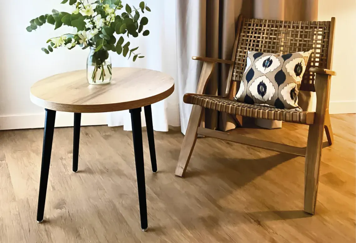 Suelo Decoblu Flooring de acabado madera con una mesa y un sillón